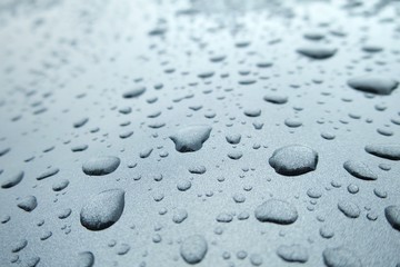 Rain drops on the window or car roof in rainy day. Selective focus. Background concept.