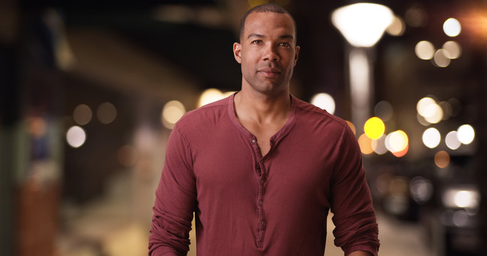 An African American Man Posing For A Portrait In A Metropolitan Area. A Black Guy Stands On The Street Corner Of A Busy City 