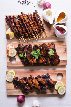 Table Set Of Filipino Dishes Like Pork And Chicken Barbecue, Eggplant Salad And Mango Cream Graham