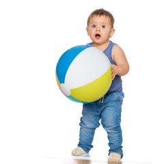 A little boy is playing with a ball.