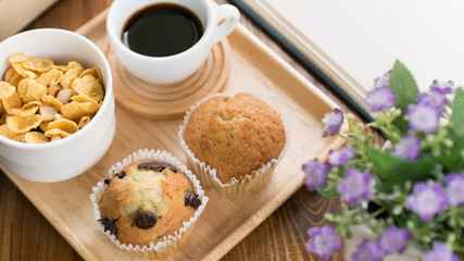 Chocolate chip muffin and cup of coffee on wooden table for relaxation time