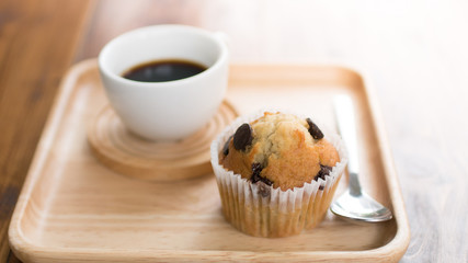 Chocolate chip muffin and cup of coffee on wooden table for relaxation time