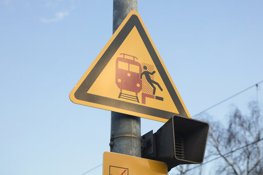 Signboard in german train station, bewaring people paying attention when train comes and not falling in rail tracks