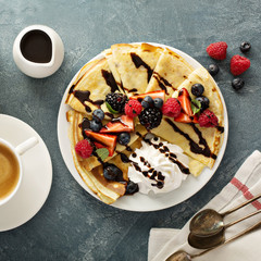 Thin crepes with whipped cream and berries