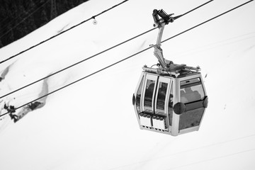 close up on cable cabin gondola taking people to the top of snowy mountain to ski slopes © Barbara C