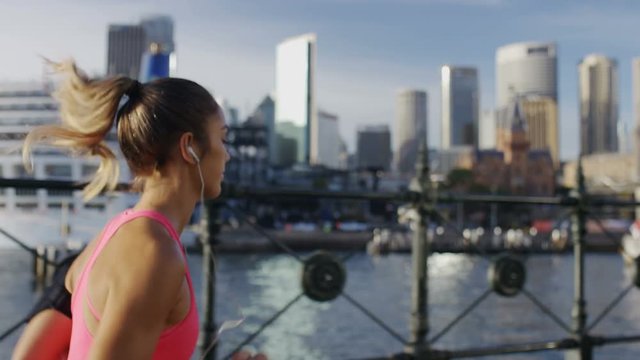 Young female jogger running with the city in the background, in slow motion