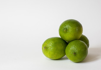 Four limes in a pile isolated on white background