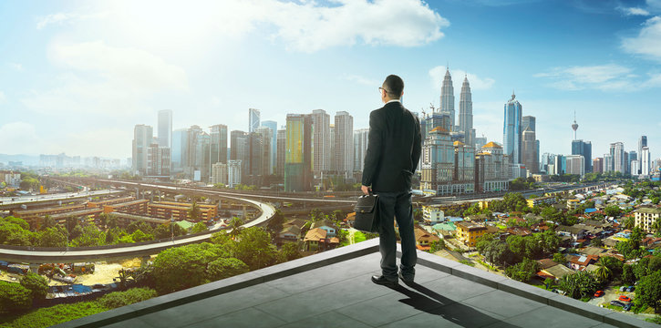 Businessman Stand At Rooftop Looking Great Cityscape View And Thinking Business Plan Of The Future .