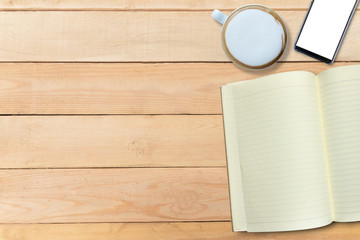 Mock up empty book and hot cappuccino and mobile phone on wooden table, copy space, for presentation product