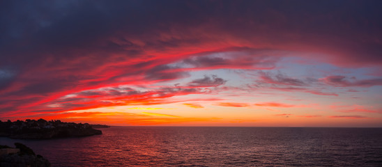 Drone aerial view of a Fiery sunrise with multicolored clouds. Mallorca Island, Spain. Summer season
