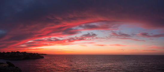Drone aerial view of a Fiery sunrise with multicolored clouds. Mallorca Island, Spain. Summer season