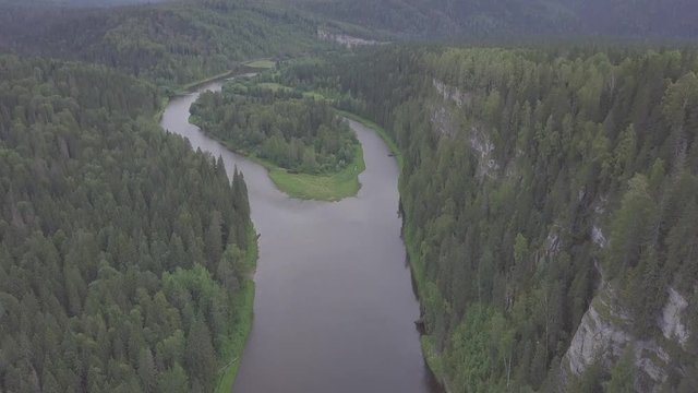 Flying over the beautiful mountain River and beautiful forest. Clip. Aerial view of mystical river at sunrise with fog, sun above the river aerial