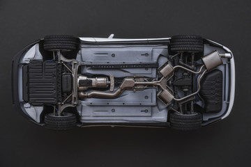 inverted car on a black background. bottom view of car
