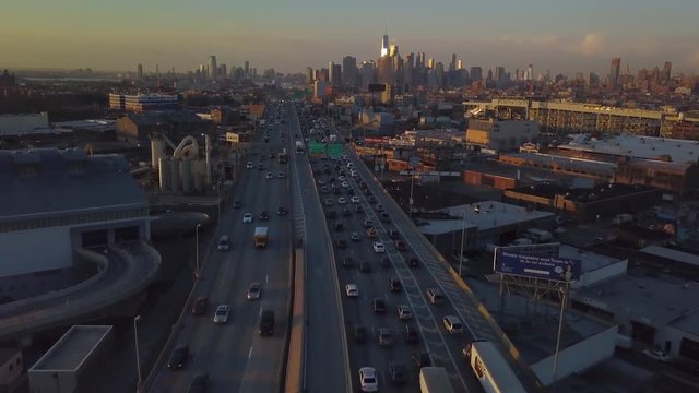 alt sunset flying backwards over highway away from Manhattan skyline