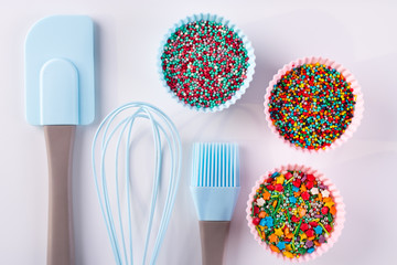 Set of kitchenware for cooking pastries and  Rainbow sprinkles for decoration on white background