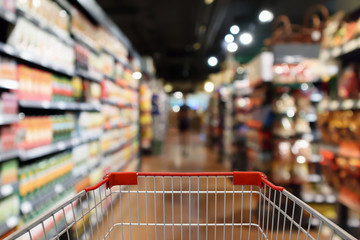 Shopping cart with supermarket aisle blur abstract background - Powered by Adobe