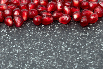 pomegranate seeds over black background