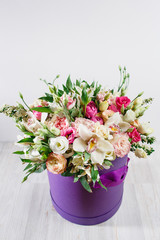 beautiful bouquet of mixed flowers in a vase on wooden table. the work of the florist at a flower shop