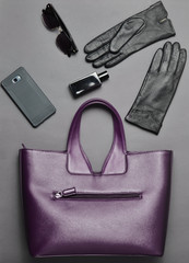 Accessories for business lady, gadgets layout on a gray background, top view. Leather bag,...