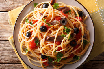 Pasta Alla Puttanesca with anchovies and black olives. horizontal top view