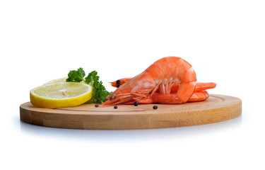 Shrimps with slices of lemon on cutting board isolated on white background.