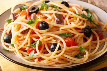 Pasta Alla Puttanesca with anchovies and black olives macro. horizontal
