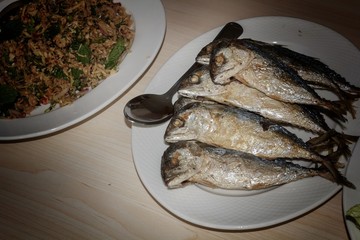 Fried fish in a plate on the table.