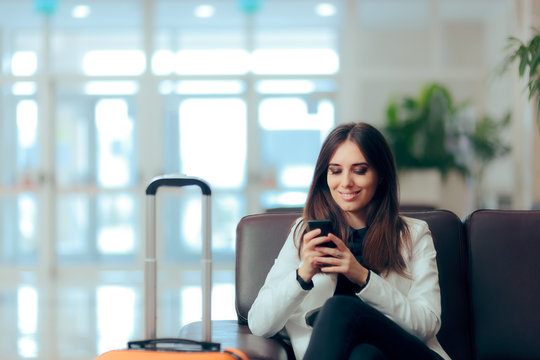 Woman Reading Phone Messages in Airport Waiting Room