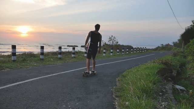 Man gonna surf spot on motorcycle with surfboard. Surfing lifestyle