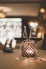 Two glasses of wine on the table near the candle in the evening in the restaurant. Secular party.