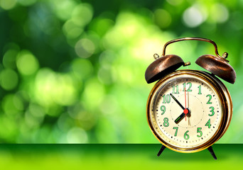 Retro clock on a light green-dark green with Nature green bokeh background