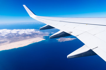 Obraz premium Wing of airplane above island
