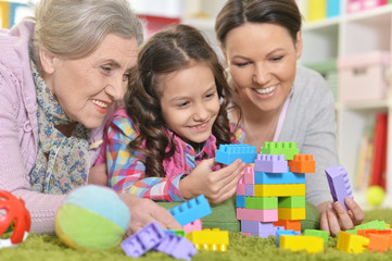 Obraz na płótnie Canvas family playing with colorful plastic blocks