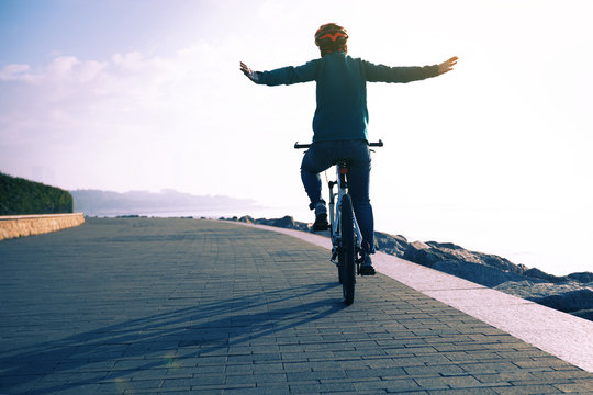  cycling enthusiast riding bike in the sunrise coast path