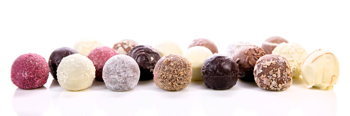 Verschiedene Pralinen oder Trüffel aus Schokolade vor Weiß, Panorama