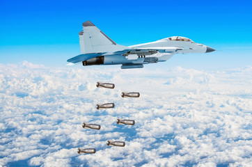 Military fighter aircraft flying drops bombs from a great height. Military operation bombing.