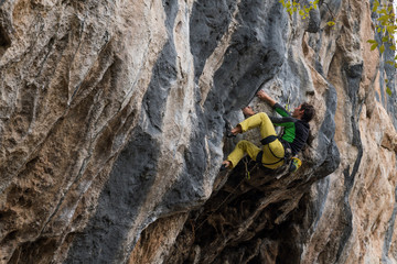 Men climbs a rock with a rope, lead