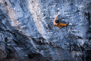 Bare torso men climbs a tufa rock with a rope, lead, Turkey