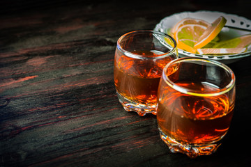 A glass of alcohol and sliced lemon.