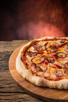 Pizza. Tasty fresh italian pizza with bacon cihili pepper and onion served on old wooden table