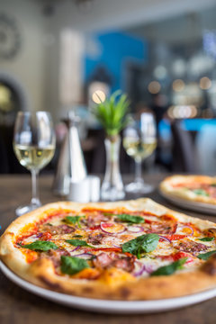 The served dinner table with pizza in pizzeria or  restaurant.