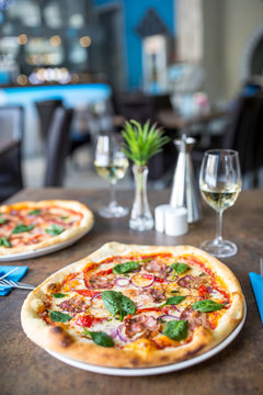 The served dinner table with pizza in pizzeria or  restaurant.