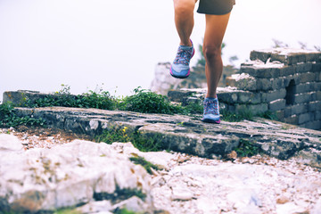 sporty fitness woman runner running on mountain top