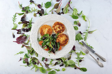 pancakes with potato salad in a bowl on a marble background