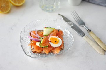 sandwich with salmon, cucumber, egg and onion