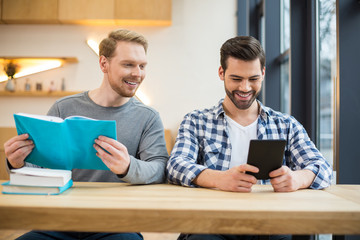 Obraz premium Joyful nice men reading books