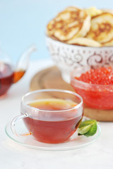 transparent glass mug with black tea and mint