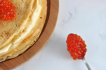 teaspoon with red caviar and pancakes.