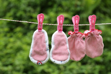 Baby gloves hanging on the clothesline with green Nature background