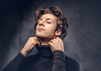 Portrait of a charismatic sensual male in black sweater. Creativ